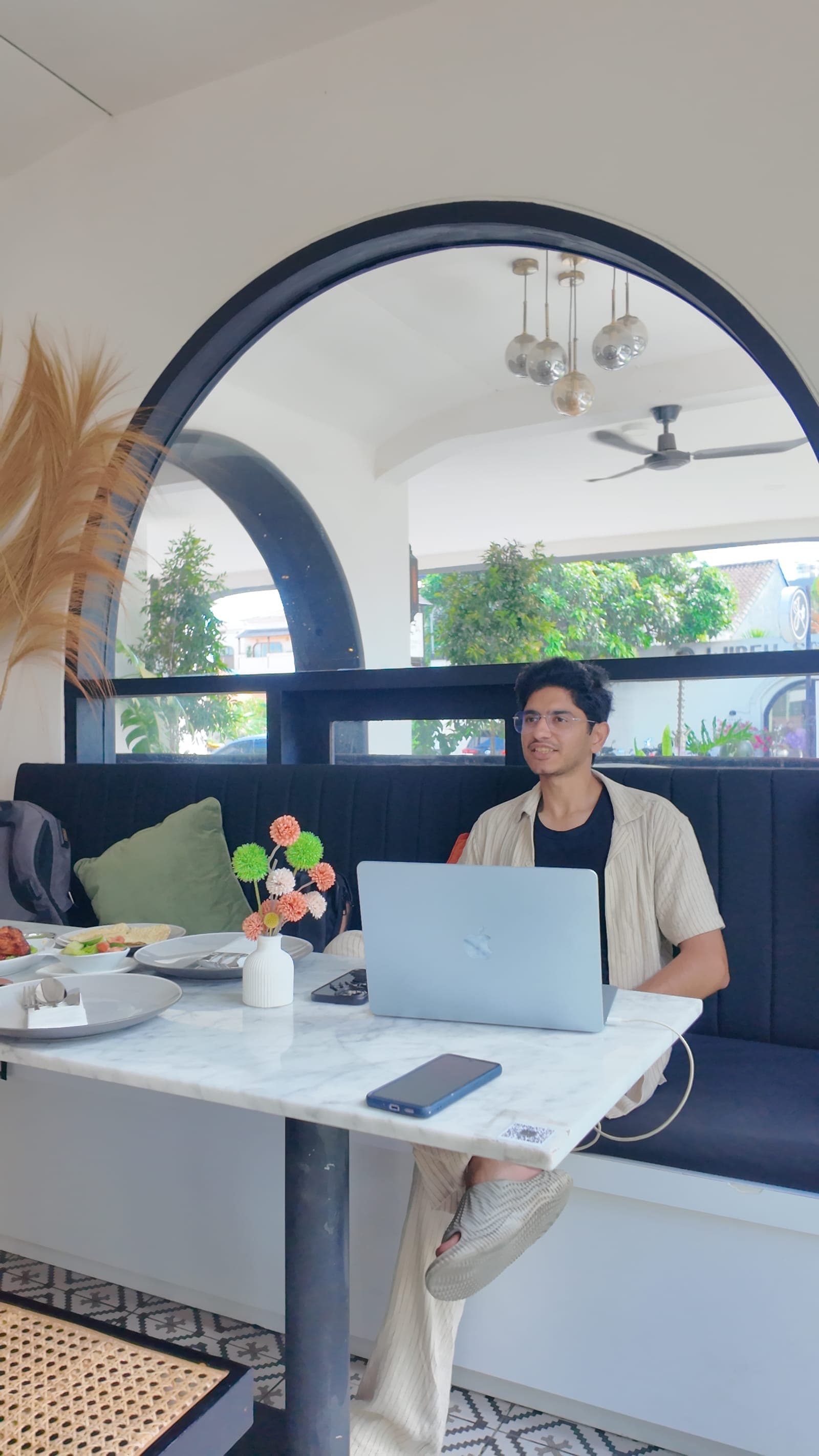 Waseem Nasir vibe coding at a Bali cafe with Claude Code open on the laptop