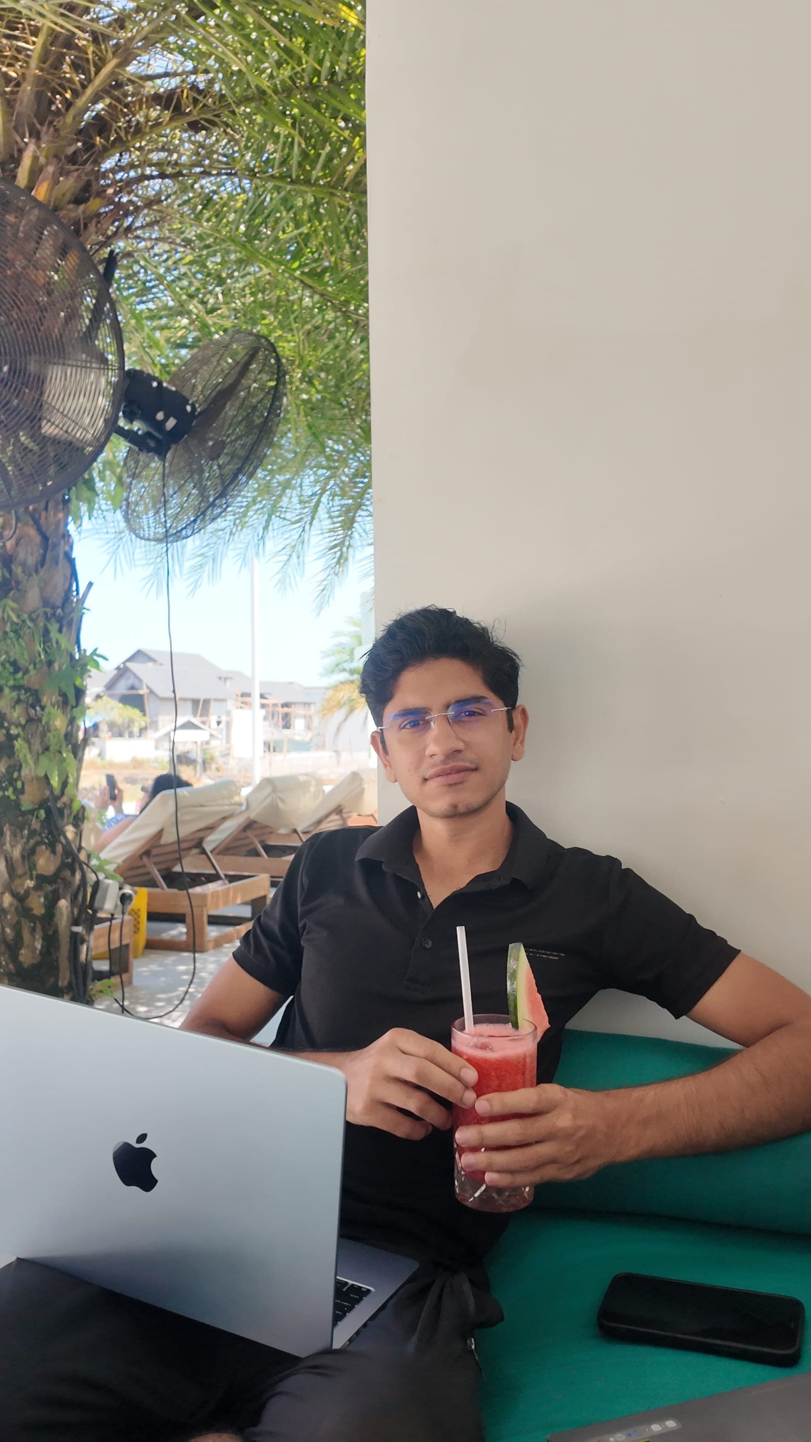 Waseem poolside in Bali with the laptop, nomad work setup